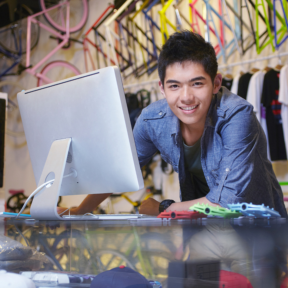 about-smb Small business owner behind a kiosk smiling. Happy about Business IT and marketing Services in Houston